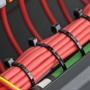 أشرطة ربط بلاستيكية سوداء تستخدم لتجميع أسلاك حمراء داخل جهاز.