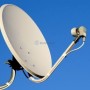 Antenne parabolique claire avec tête de réception et câble sur fond de ciel bleu.