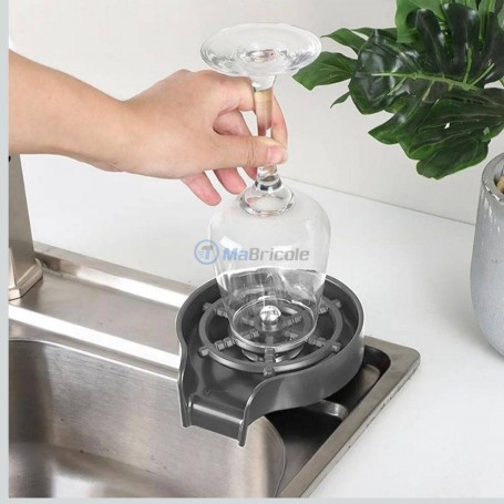 Lave-gobelets en acier inoxydable installé sur un évier avec un verre à pied tenu à l'envers.