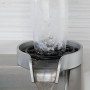 Lave-gobelets en acier inoxydable en fonctionnement avec eau qui circule dans un verre posé à l'intérieur.