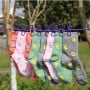 Corde à linge élastique violette avec huit pinces tenant des chaussettes colorées suspendues à l'extérieur
