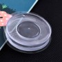 Porte objet mural rond en silicone transparent avec surface autocollante posé sur un fond noir