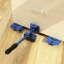 Kit de levage bleu avec palan et roulettes sous un meuble en bois clair posé sur un sol en parquet.