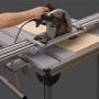 Rails de guidage en aluminium monté sur table, avec une scie circulaire utilisée pour couper du bois.