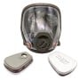 Masque de protection intégral transparent avec deux filtres détachés posés à côté.