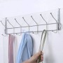 Porte manteau chromé suspendu sur une porte avec plusieurs crochets, vêtements et main tenant une lanière