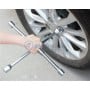 Clé en croix hexagonale positionnée sur un écrou de roue de voiture tenue par une main
